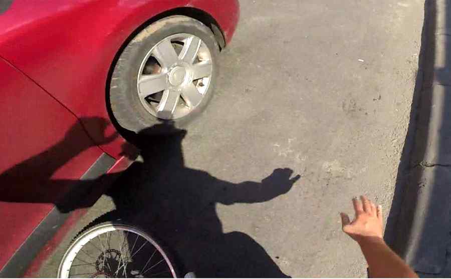 Un biciclist este aruncat câțiva metri la impactul cu o portieră deschisă brusc în trafic (video)