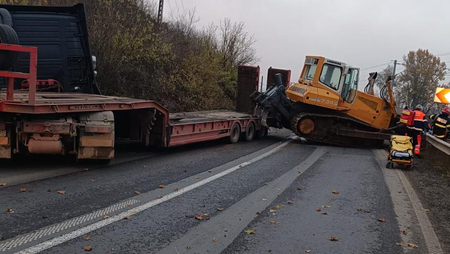 Accident şocant: Maşină strivită de un buldoexcavator căzut de pe trailer