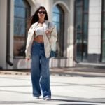 Femeie purtând pantofi sport și o jachetă bomber, în stil streetwear