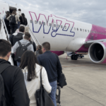 Persoane care se îmbarcă într-o aeronavă pentru a pleca la muncă în străinătate