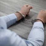 Două mâini încătușate, imagine ilustrativă pentru condamnarea la închisoare a celor doi bărbați implicați în furtul banilor de pensii de la Poșta Mare din Timișoara.