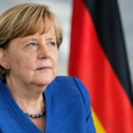 Imagine ilustrativă cu Angela Merkel, fostul cancelar al Germaniei, pe fundalul drapelelor Germaniei și Uniunii Europene.