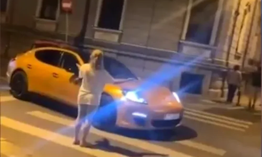 VIDEO Zebră de lux în București. O femeie a traversat pe capota unui Porsche oprit pe trecerea de pietoni